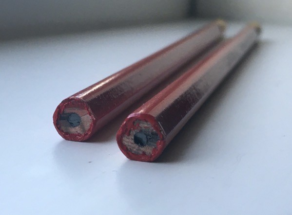 A view of two Try-Rex pencils from the end, showing their triangular shape